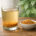 Transparent glass of soaked methi dana water with fenugreek seeds on a wooden table, ayurvedic home remedy image