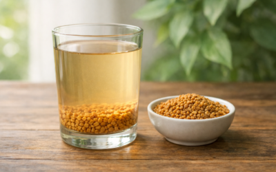 Transparent glass of soaked methi dana water with fenugreek seeds on a wooden table, ayurvedic home remedy image